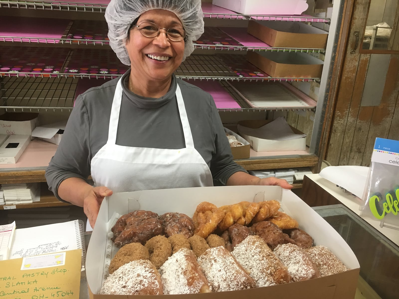 Vera Slamka, owner of Central Pastry, arranges one of the three boxes of doughnuts that were delivered to the Middletown police department Tuesday. 