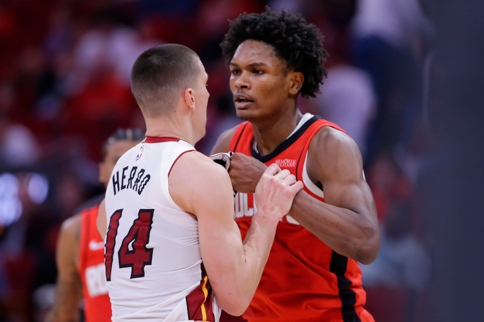 Houston Rockets forward Amen Thompson, right, and Miami Heat guard Tyler Herro (14) tug on each other before Thompson throws Herro to the court sparking a bench clearing brawl resulting in multiple ejections for both teams during the second half of an NBA basketball game Sunday, Dec. 29, 2024, in Houston. (AP Photo/Michael Wyke)