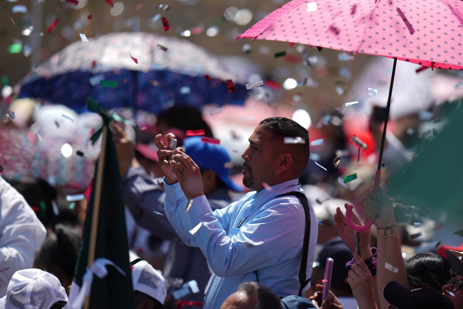 Supporters of President Claudia Sheinbaum watch her address at a rally she convened to welcome U.S. President Donald Trump's decision to postpone tariffs on Mexican goods for one month, at the Zocalo, Mexico City's main square, Sunday, March 9, 2025. (AP Photo/Eduardo Verdugo)