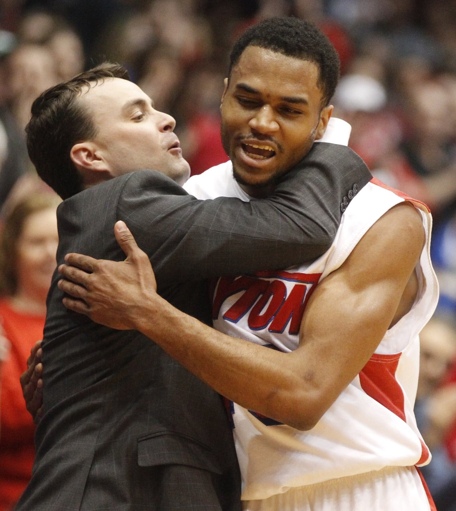 Dayton coach Archie Miller left, hugs guard Vee Sanford as Sanford leaves the game for the final time on Senior Night on Saturday, March 8, 2014, at UD Arena. David Jablonski/Staff