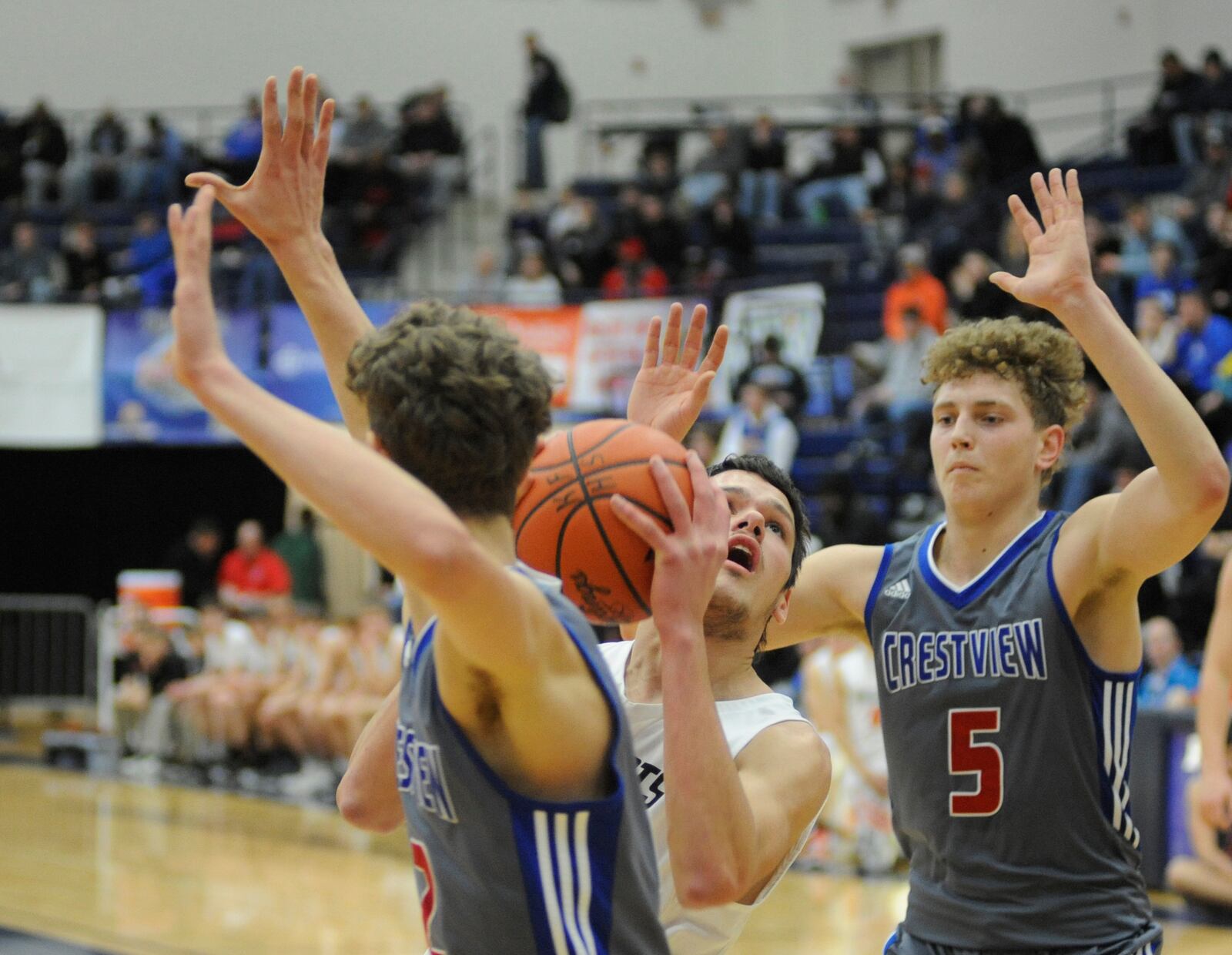 Minster’s Cody Frericks (with ball) draws two Crestview defenders. MARC PENDLETON / STAFF