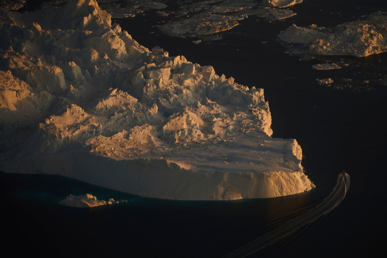 A boat sails past a large iceberg in Ilulissat, Greenland, Wednesday Feb. 18, 2025. (AP Photo/Emilio Morenatti)