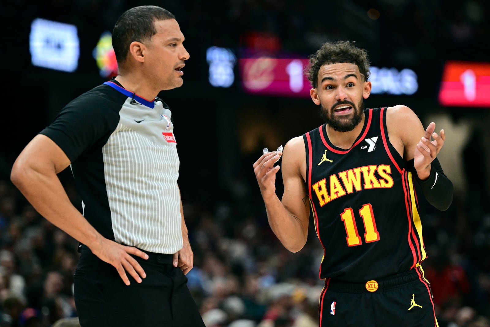 Atlanta Hawks guard Trae Young disputes a call with official Nate Green in the first half of an NBA basketball game against the Cleveland Cavaliers, Wednesday, Nov. 27, 2024, in Cleveland. (AP Photo/David Dermer)