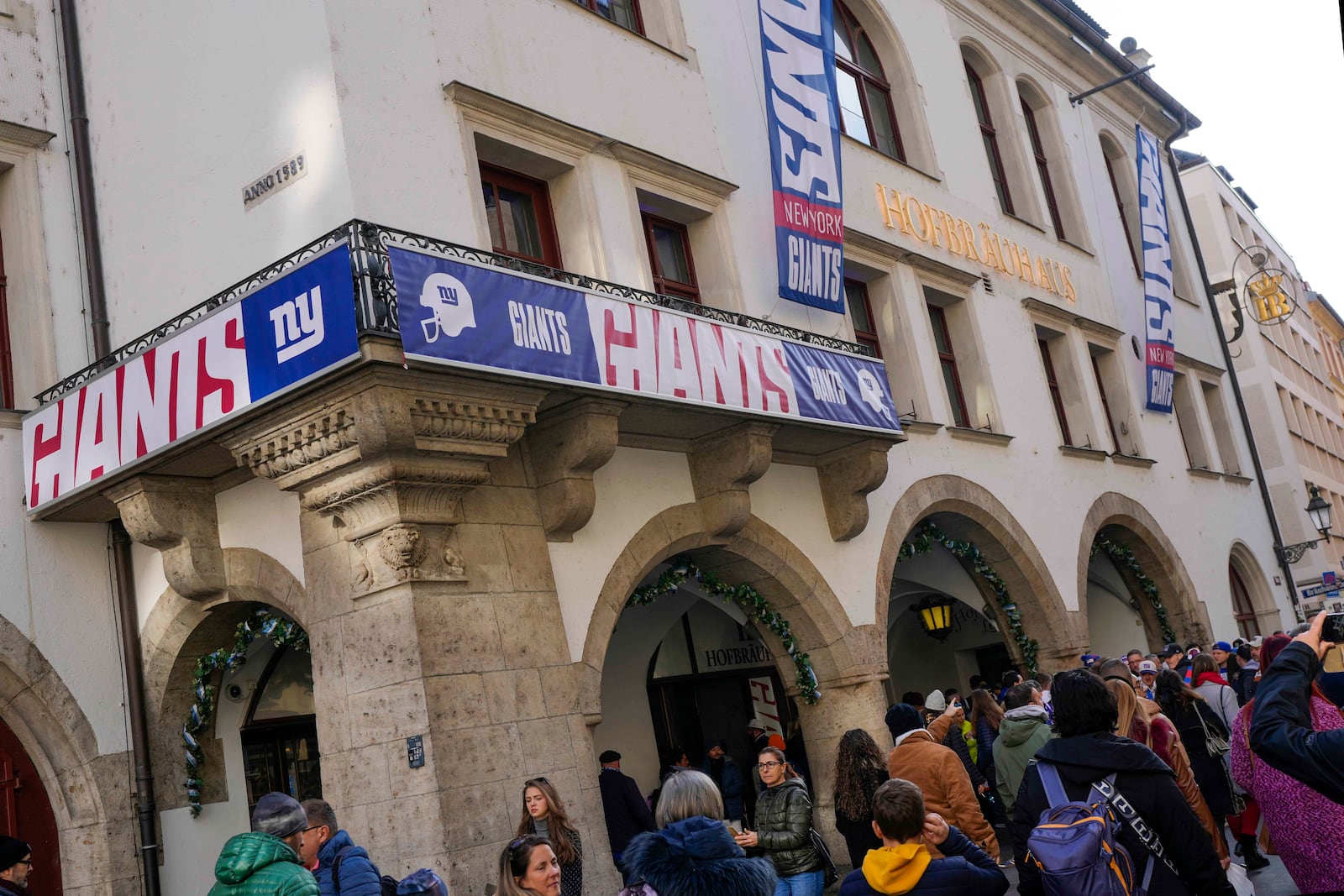 New York Giants supporters queue outside the traditional 'Hofbraeuhaus' in Munich, Germany, Saturday, Nov. 9, 2024 ahead of the NFL match between the Carolina Panthers and the New York Giants in Munich on Sunday. (AP Photo/Matthias Schrader)