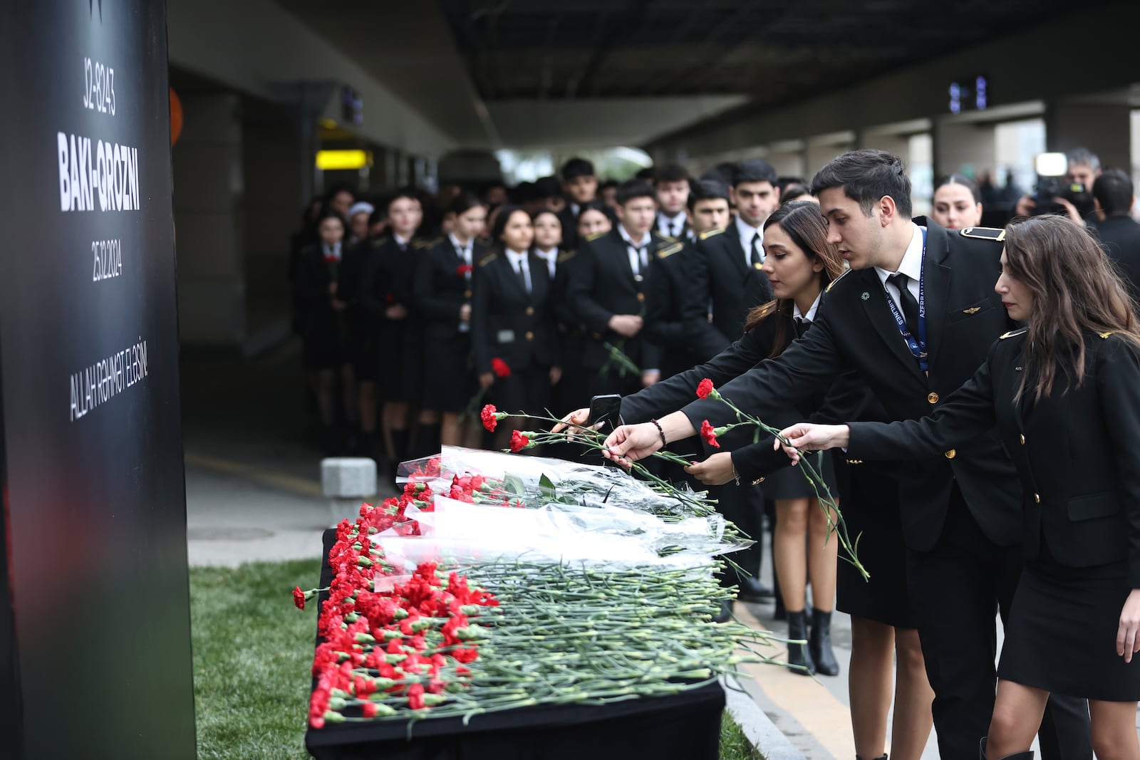 Cadets of the aviation school lay flowers in memory of victims of the Azerbaijan Airlines' Embraer 190 that crashed near the Kazakhstan's airport of Aktau, at the Heydar Aliyev International Airport outside Baku, Azerbaijan, Thursday, Dec. 26, 2024. (AP Photo)