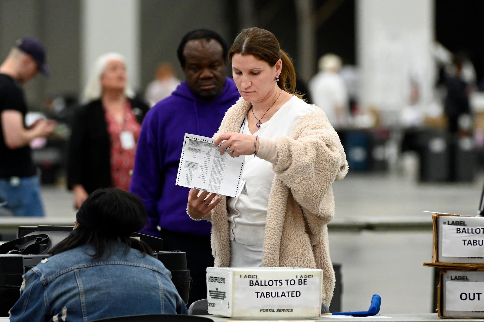 An election worker looks over an absentee voter ballot, Tuesday, Nov. 5, 2024, at Huntington Place in Detroit. (AP Photo/Jose Juarez)