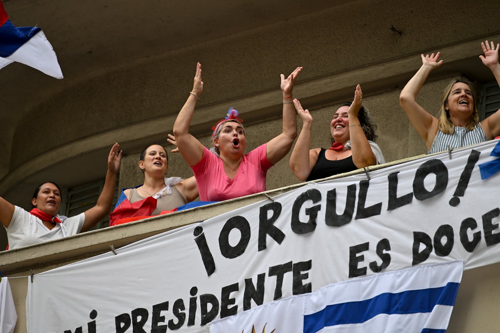 People greet Uruguay's newly sworn-in President Yamandu Orsi and Vice President Carolina Cosse as they ride by in an open car, on Inauguration Day in Montevideo, Uruguay, Saturday, March 1, 2025. (AP Photo/Santiago Mazzarovich)