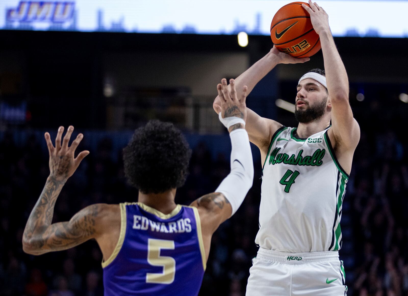 Marshall guard Jacob Conner (4) shoots against James Madison guard Terrence Edwards Jr. (5) during the first half of an NCAA college basketball game in Harrisonburg, Va., Saturday, Jan. 20, 2024. (Daniel Lin/Daily News-Record via AP)