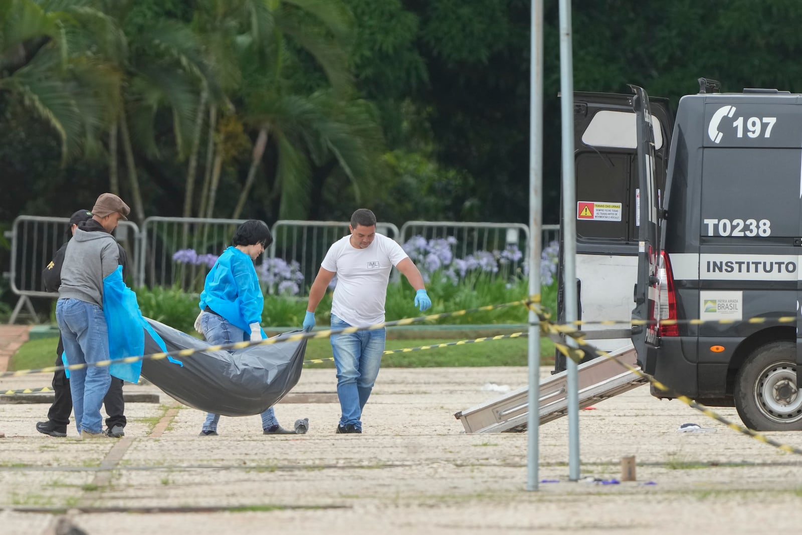 Forensic officers collect a body outside the Supreme Court following an explosion the previous night in Brasilia, Brazil, Thursday, Nov. 14, 2024. (AP Photo/Eraldo Peres)