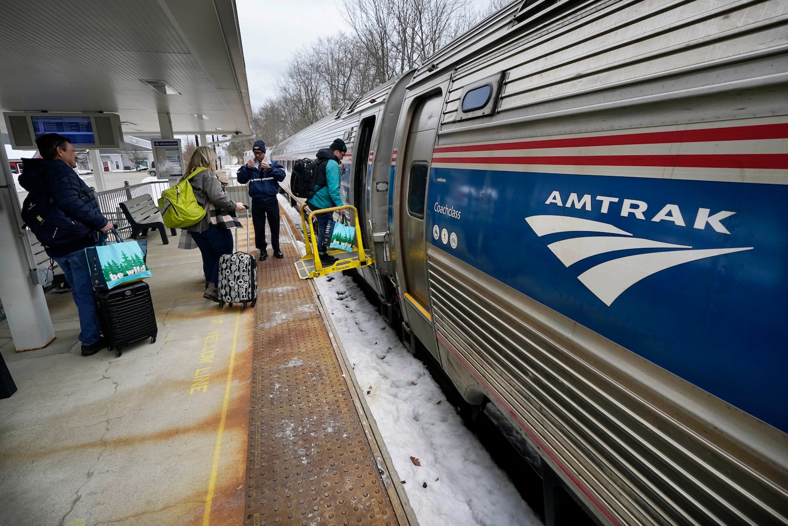 Passengers board an Amtrak Downeaster, Wednesday, March 8, 2023, in Freeport, Maine. The New Hampshire Liquor Commission says it is "exploring a creative solution" after saying an Amtrak route from Maine to Boston can't serve alcohol while passing through 35 miles of New Hampshire. (AP Photo/Robert F. Bukaty)