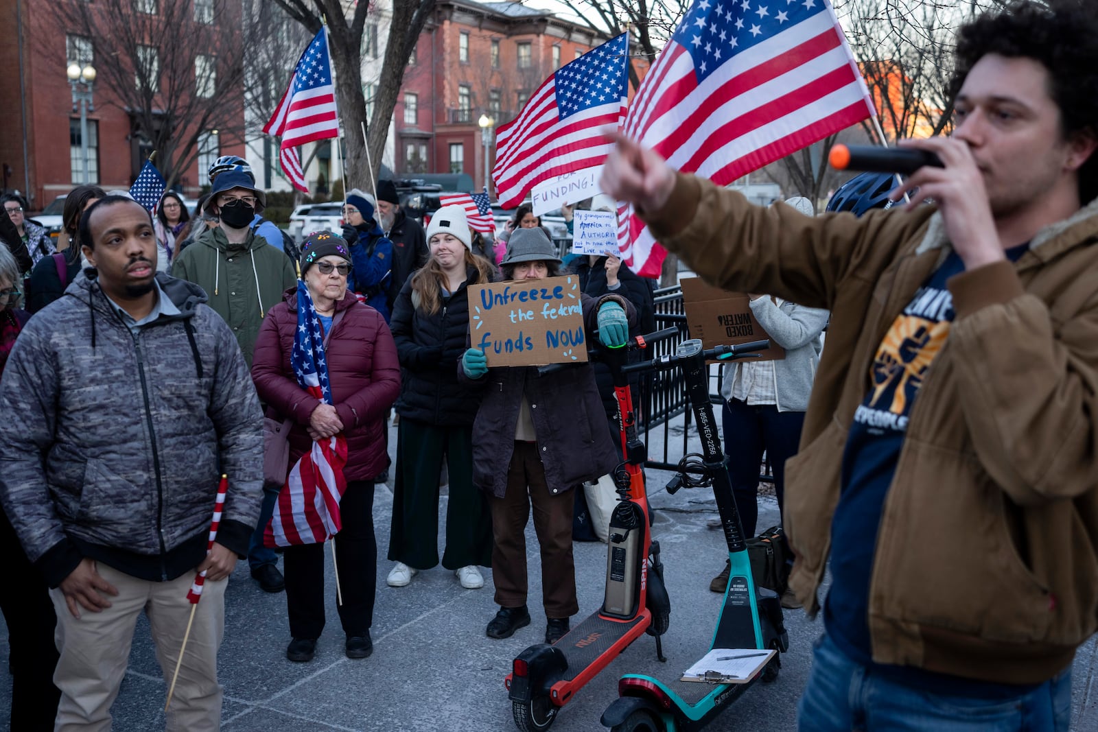 People protest against a funding freeze of federal grants and loans following a push from President Donald Trump to pause federal funding near to the White House in Washington, Tuesday, Jan. 28, 2025. (AP Photo/Ben Curtis)