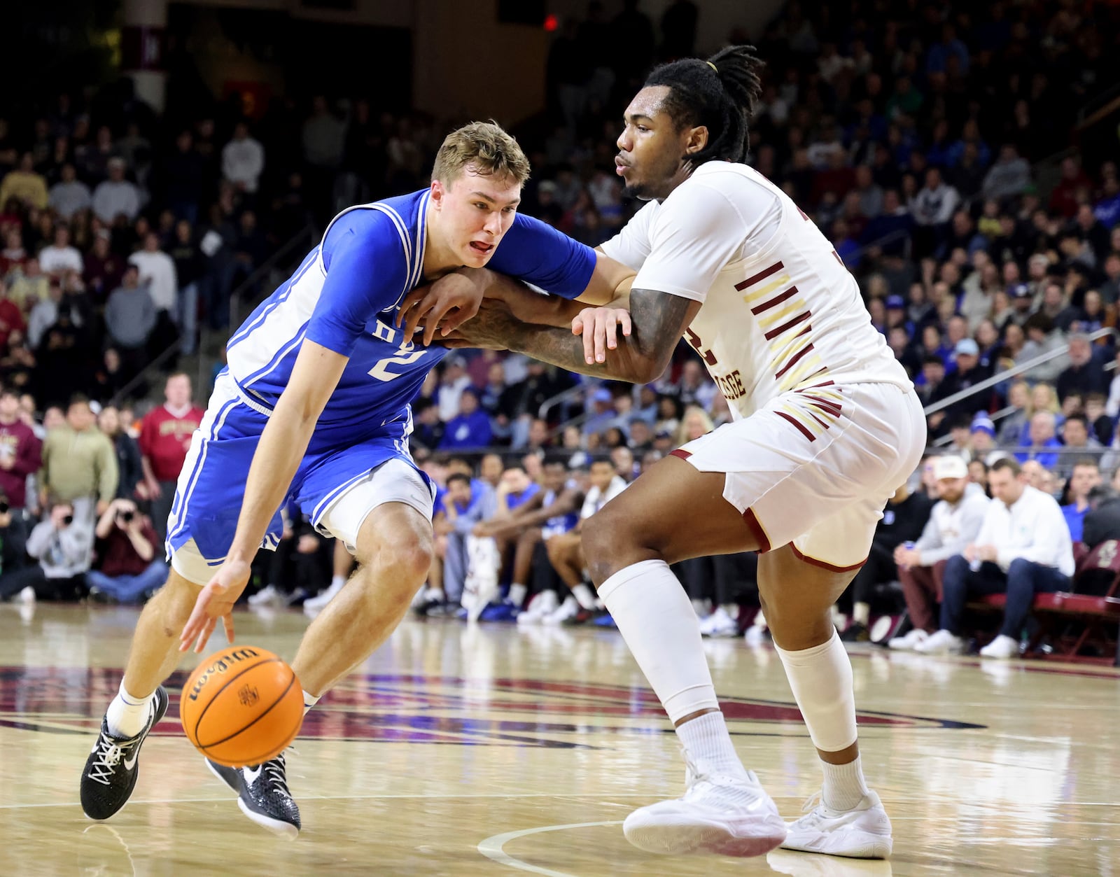 Duke guard Cooper Flagg, left, dribbles around Boston College forward Chad Venning, right, during the first half of an NCAA college basketball game Saturday, Jan. 18, 2025, in Boston. (AP Photo/Mark Stockwell)