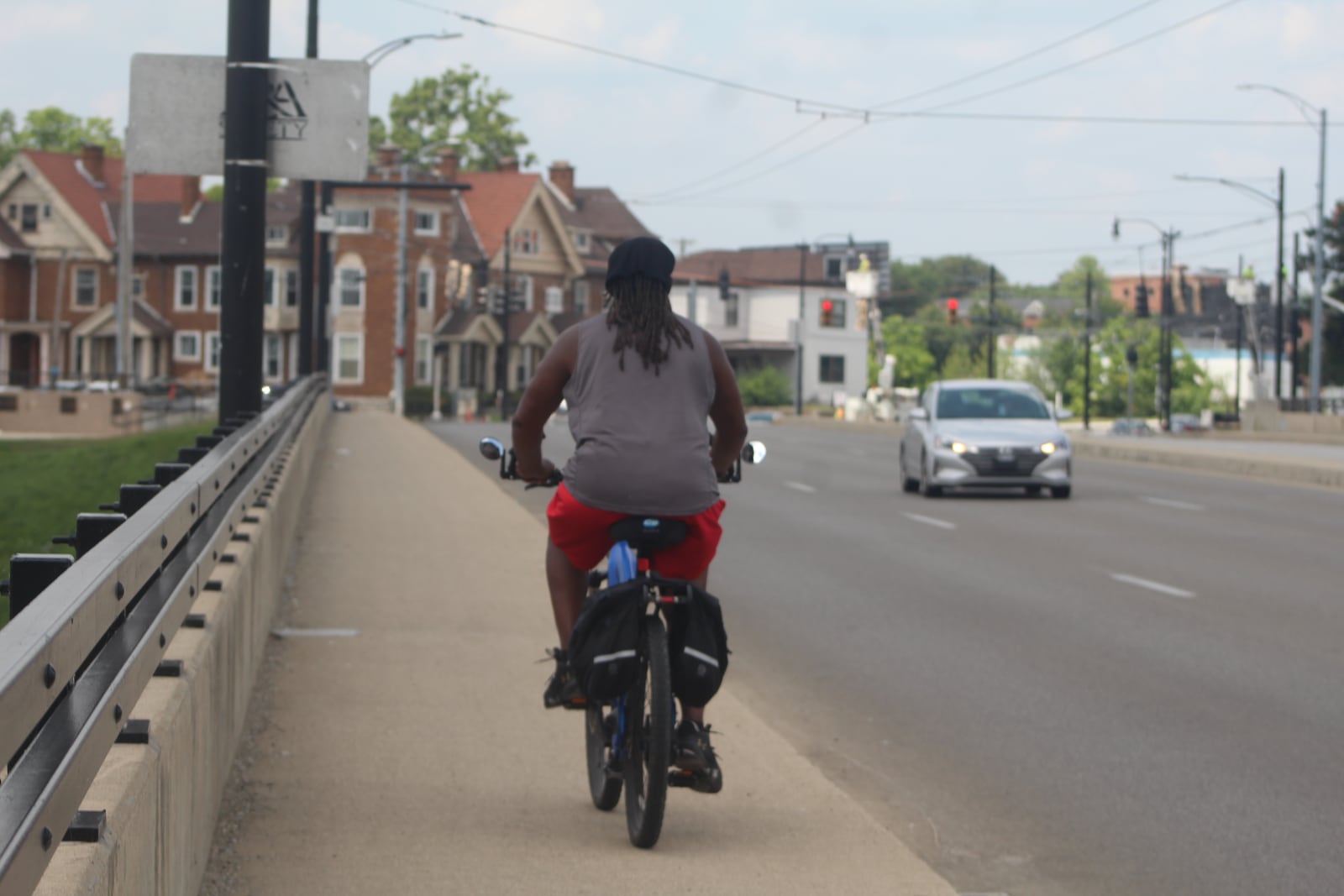 A man rides his bike on the sidewalk on the Salem Avenue bridge in Dayton. CORNELIUS FROLIK / STAFF