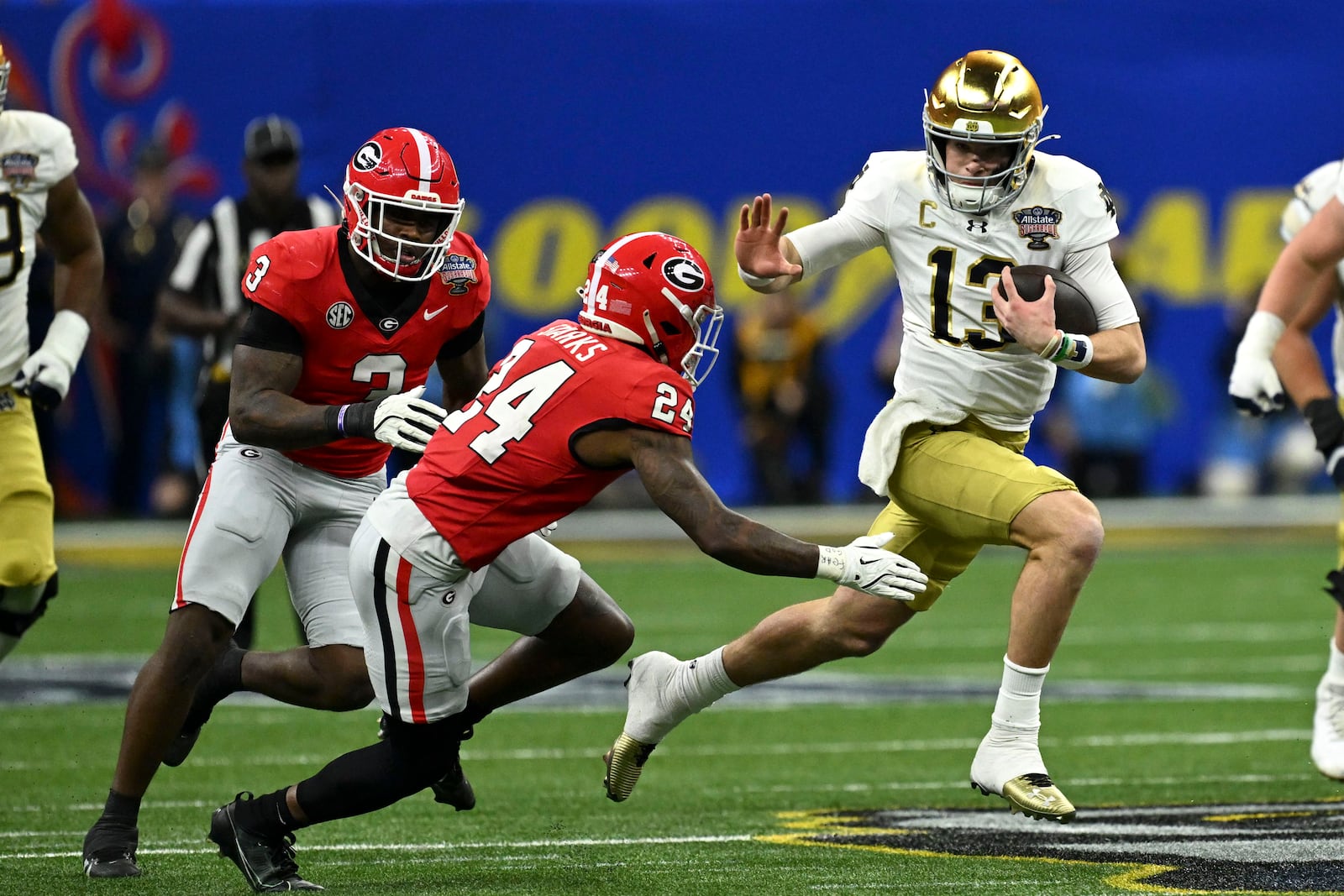 Notre Dame quarterback Riley Leonard (13) runs from Georgia defensive back Malaki Starks (24) during the first half in the quarterfinals of a College Football Playoff, Thursday, Jan. 2, 2025, in New Orleans. (AP Photo/Matthew Hinton)