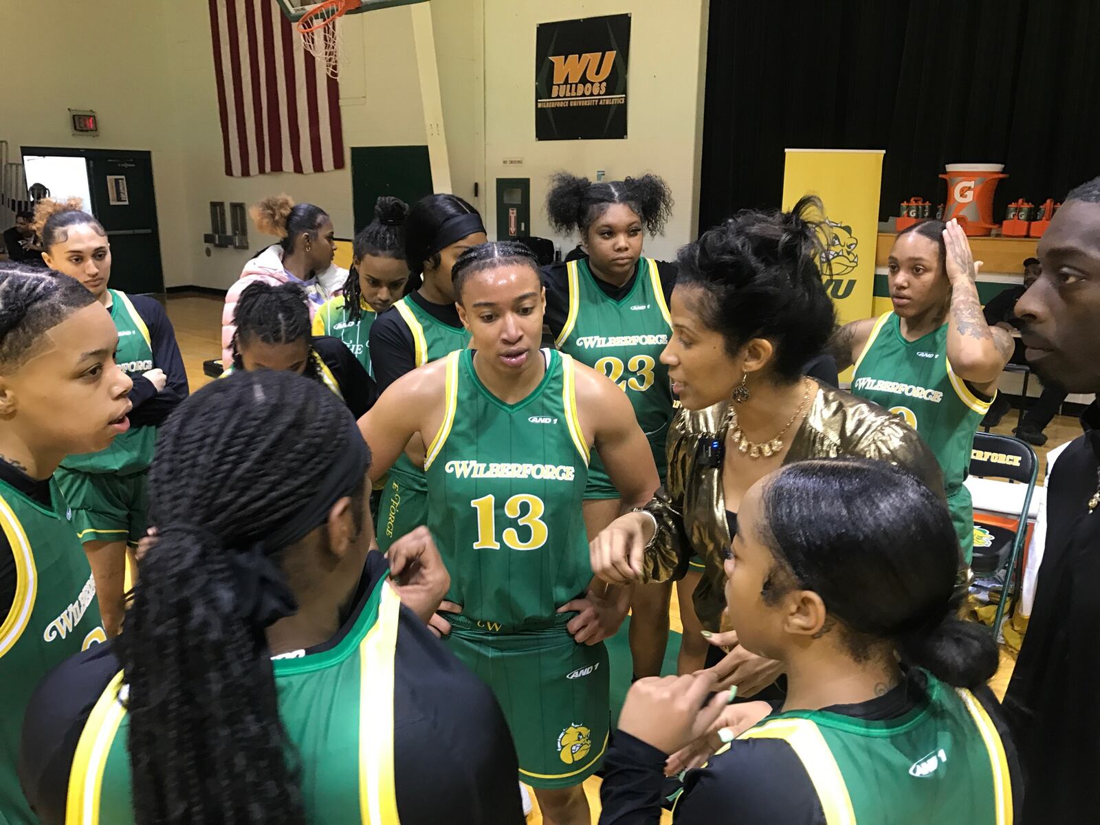 Wilberforce guard Constance “Connie” Chaplin (No. 13) listens to head coach Rachel Naughton (in gold)  during a time out late in Thursday’s game against Fisk University. Wilberforce won, 71-62. Chaplin had 15 points, tied for the team’s high and added eight rebounds and six assists, five steals and two blocked shots. Tom Archdeacon/CONTRIBUTED