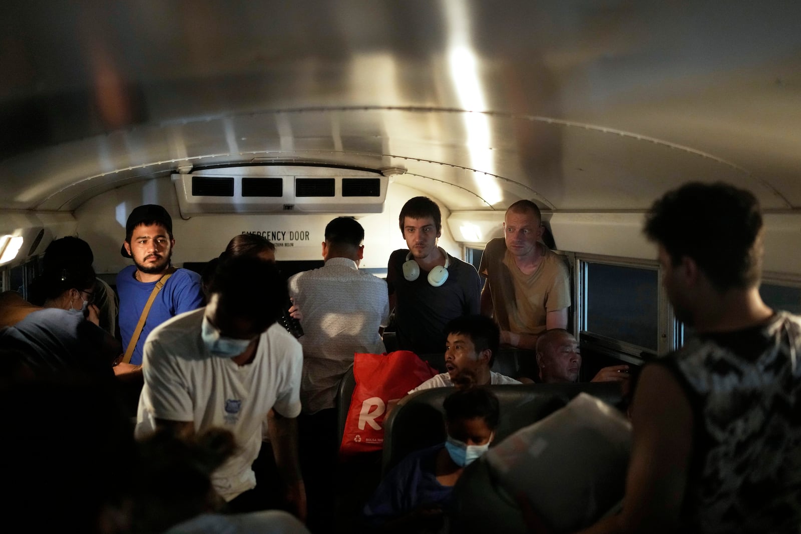 Nikita Gaponov, second from right, of Russia, and other migrants who were held in a temporary Panamanian immigration shelter after being deported from the U.S. arrive by bus in Panama City, Saturday, March 8, 2025, after authorities gave them 30 days to leave the country. (AP Photo/Matias Delacroix)