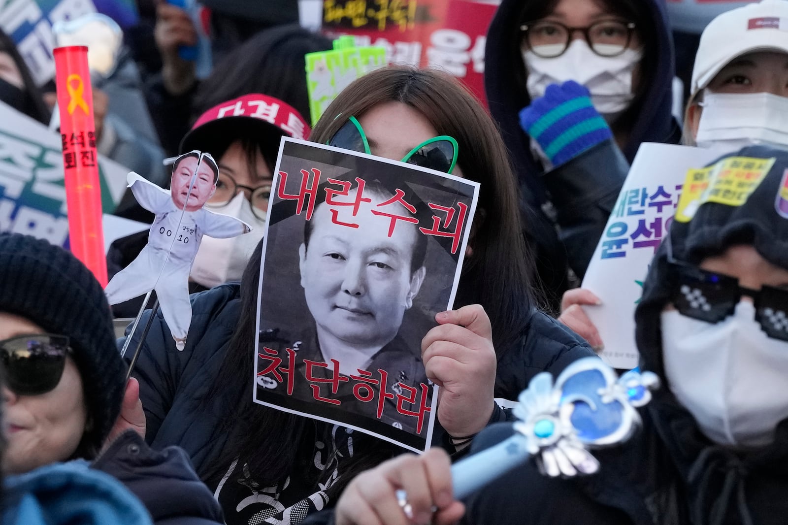 A protester holds images of impeached South Korean President Yoon Suk Yeol during a rally demanding immediate indictment of Yoon in Seoul, South Korea, Saturday, Jan. 25, 2025. The letters read "Punish the rebellion leader Yoon Suk Yeol." (AP Photo/Ahn Young-joon)