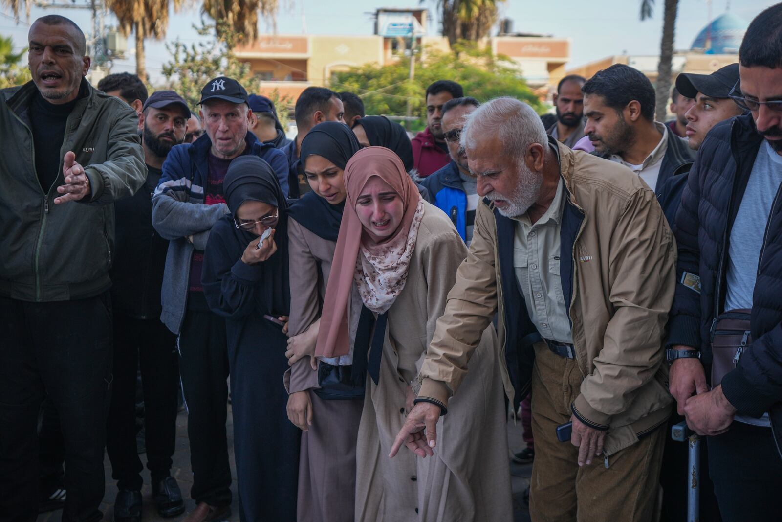 Palestinians mourn over the bodies of victims of an Israeli army strike on the Nuseirat refugee camp, at the Al-Aqsa Martyrs hospital in Deir al-Balah, Gaza Strip, Thursday Dec. 12, 2024. Palestinian medical officials say Israeli airstrikes have killed at least 28 people in the Gaza Strip, including seven children and a woman. (AP Photo/Abdel Kareem Hana)