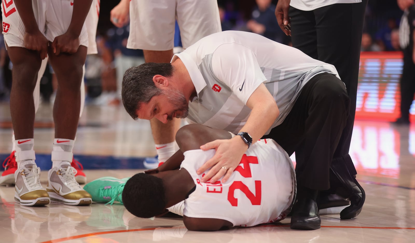 Dayton trainer Mike Mulcahey attends to Kobe Elvis after he was injured during a game against BYU in the Battle 4 Atlantis on Friday, Nov. 25, 2022, in Nassau, Bahamas. David Jablonski/Staff