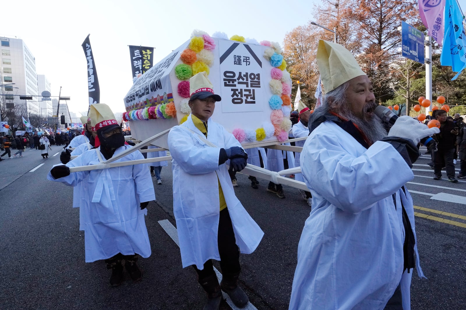 Farmers carry a coffin symbolizing South Korean President Yoon Suk Yeol's government before a rally to demand his impeachment outside the National Assembly in Seoul, South Korea, Saturday, Dec. 14, 2024. The signs read " Yoon Suk Yeol's government. " (AP Photo/Ahn Young-joon)