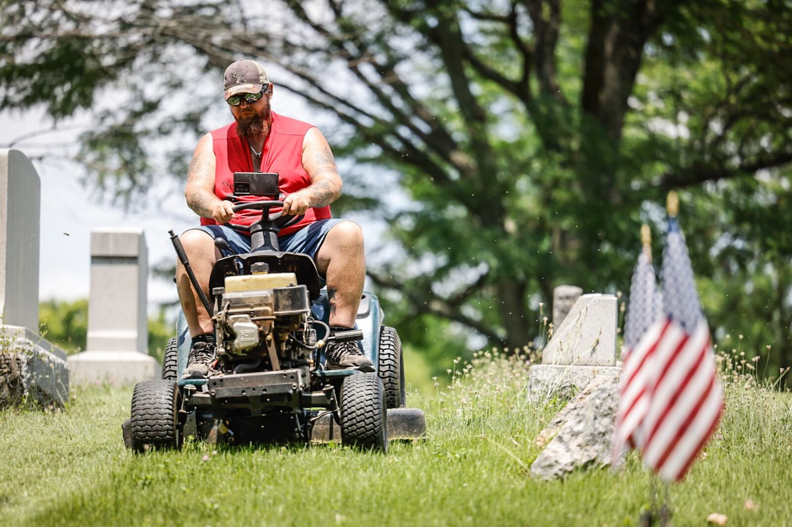 Volunteer Andy Jones cuts the grass at Bear Creek Hill Grove Cemetery on Union Road in Trotwood. The City of Trotwood has filed a lawsuit against the cemetery citing resident complaints. JIM NOELKER/STAFF