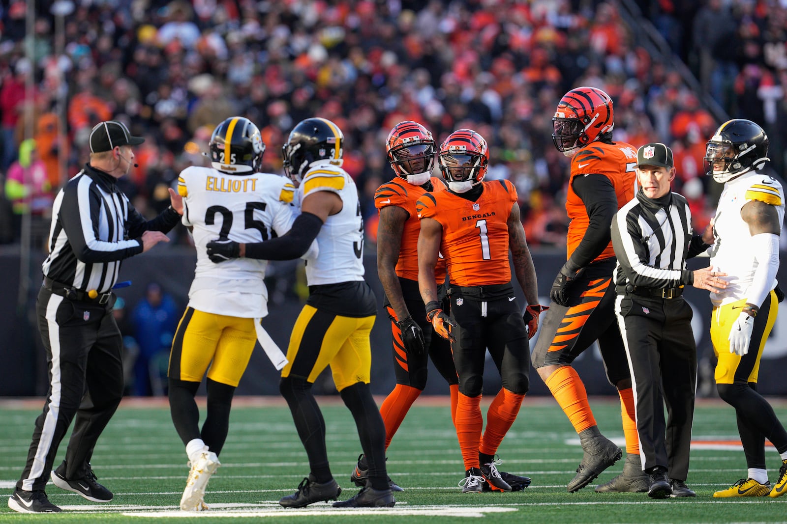 Pittsburgh Steelers safety Minkah Fitzpatrick, third from left, holds DeShon Elliott (25) away from Cincinnati Bengals wide receiver Ja'Marr Chase (1) during the second half of an NFL football game Sunday, Dec. 1, 2024, in Cincinnati. (AP Photo/Jeff Dean)