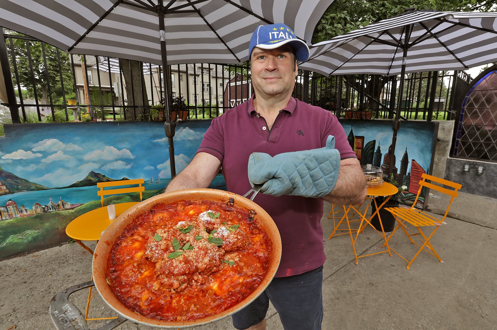 Tom Thompson, the owner and chef at Eatly American/Italian  Comfort Cafe, with one of his ravioli and meatball dishes. BILL LACKEY/STAFF 