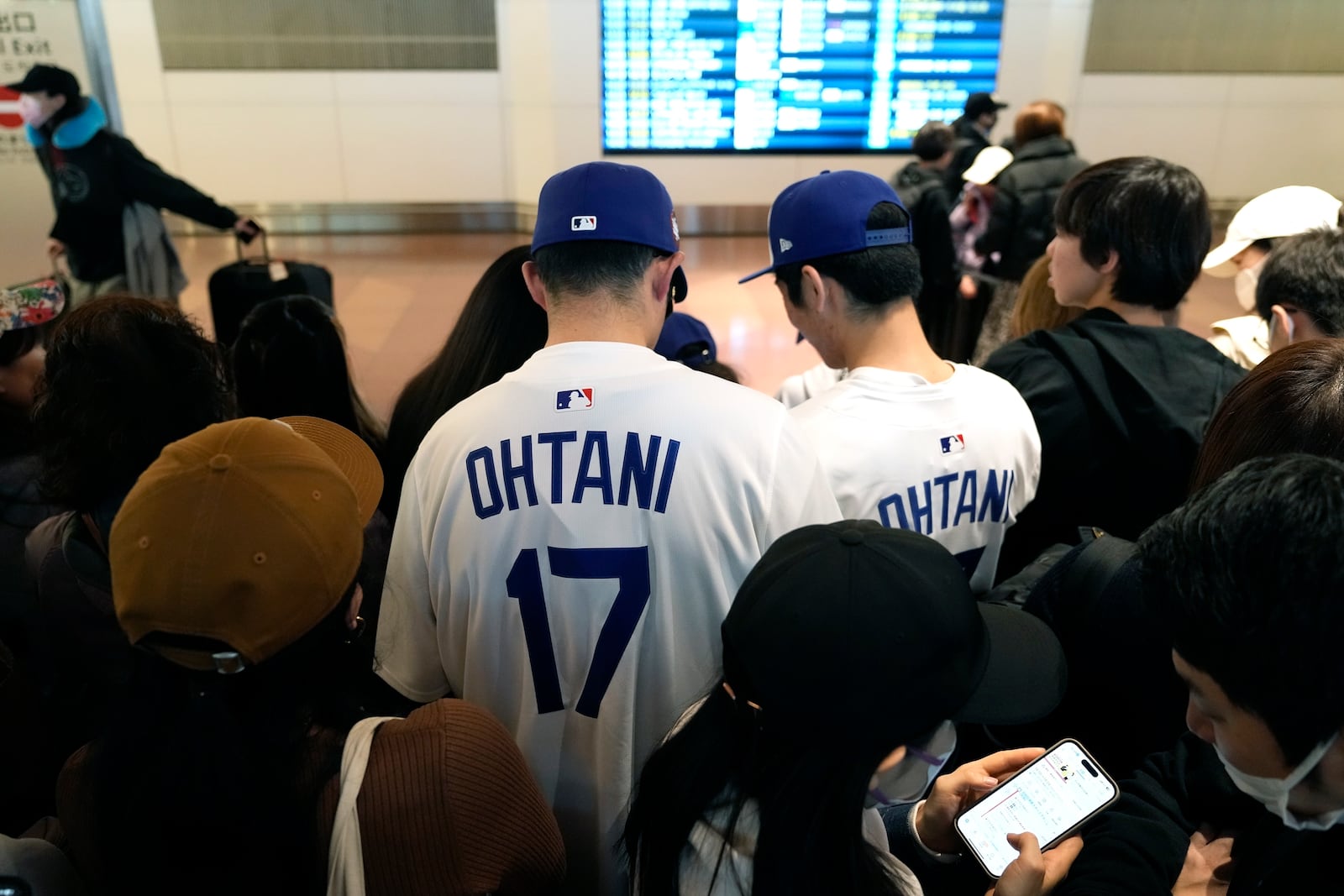 Fans of Los Angeles Dodgers's Shohei Ohtani wait for the team arrival at Tokyo International Airport Thursday, March 13, 2025, in Tokyo, as Dodgers is scheduled to play their MLB opening games against Chicago Cubs in Tokyo on March 18-19. (AP Photo/Hiro Komae)