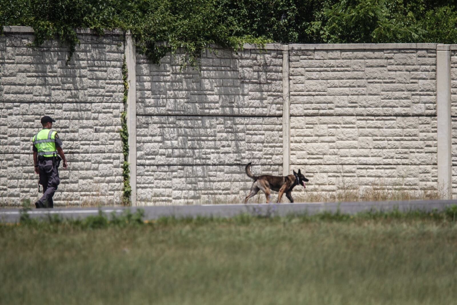 A K-9 crew searches the sides on I-75 south of Austin Blvd. after a shooting on the highway. JIM NOELKER/STAFF