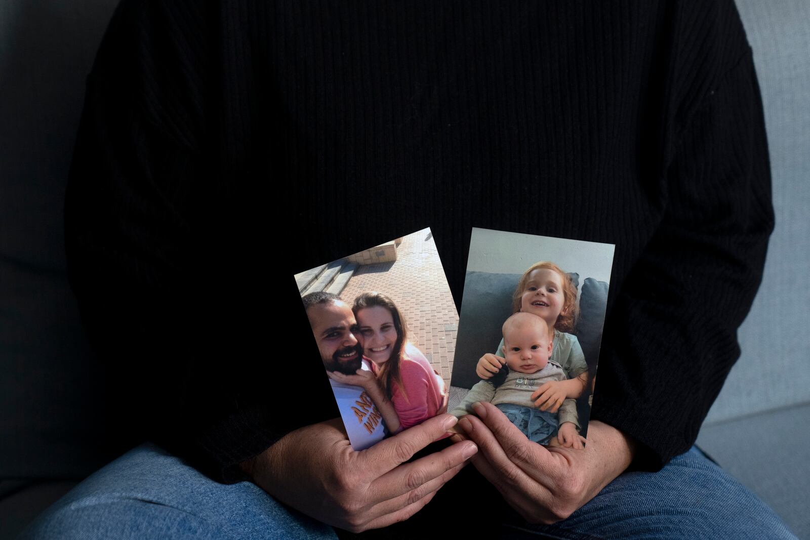 Yifat Zailer shows photos of her cousin, Shiri Bibas, center, her husband Yarden, left, and their sons Ariel, top right, and Kfir, who are being held hostage by Hamas militants in the Gaza Strip, at home in Herziliyya, Israel, on Wednesday, Jan. 15, 2025. (AP Photo/Maya Alleruzzo)