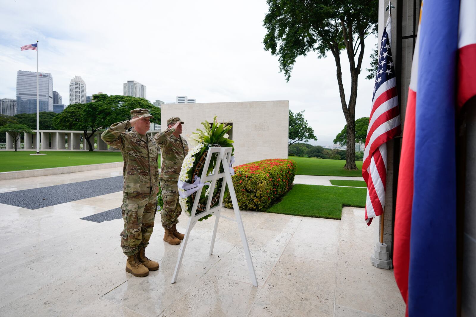 U.S. Maj. Gen. Marcus Evans, left, commanding general of the U.S. Army's 25th Infantry Division and Sgt. Major Shaun Curry salute during a wreath laying rite to honor American soldiers died during World War II at the Manila American Cemetery and Memorial in Taguig, Philippines Monday, Oct. 21, 2024. (AP Photo/Aaron Favila)