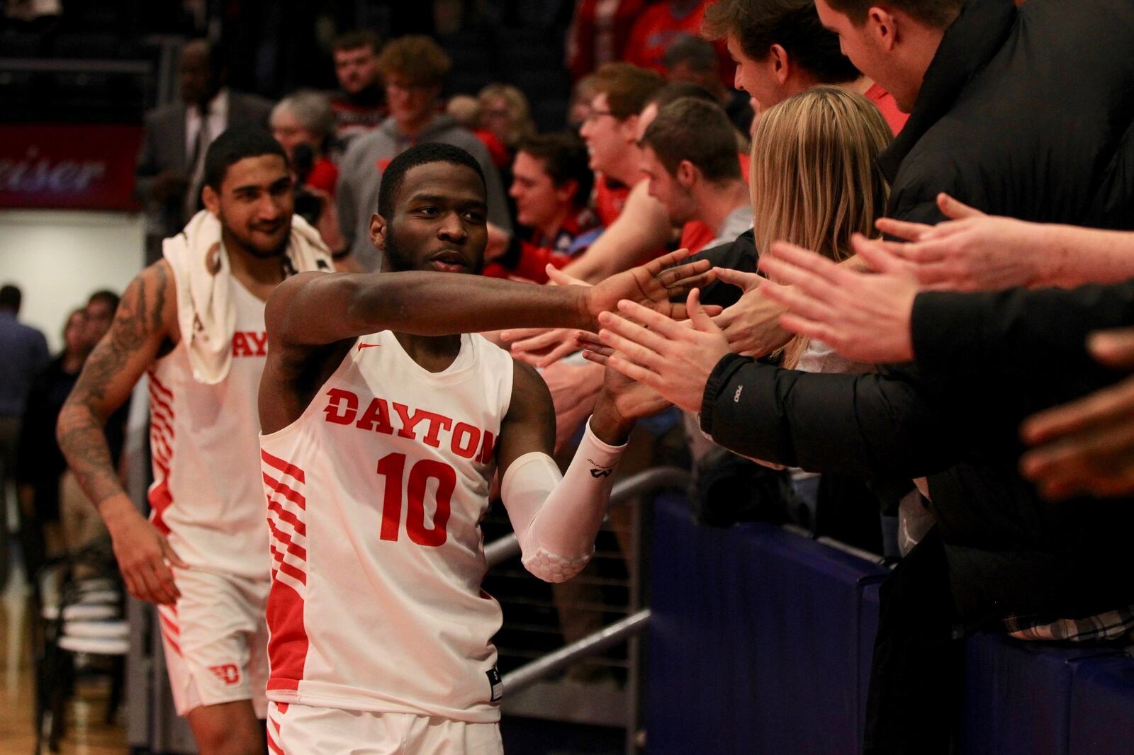 Dayton’s Jalen Crutcher slaps hands with fans after a victory against Drake on Saturday, Dec. 14, 2019, at UD Arena. David Jablonski/Staff