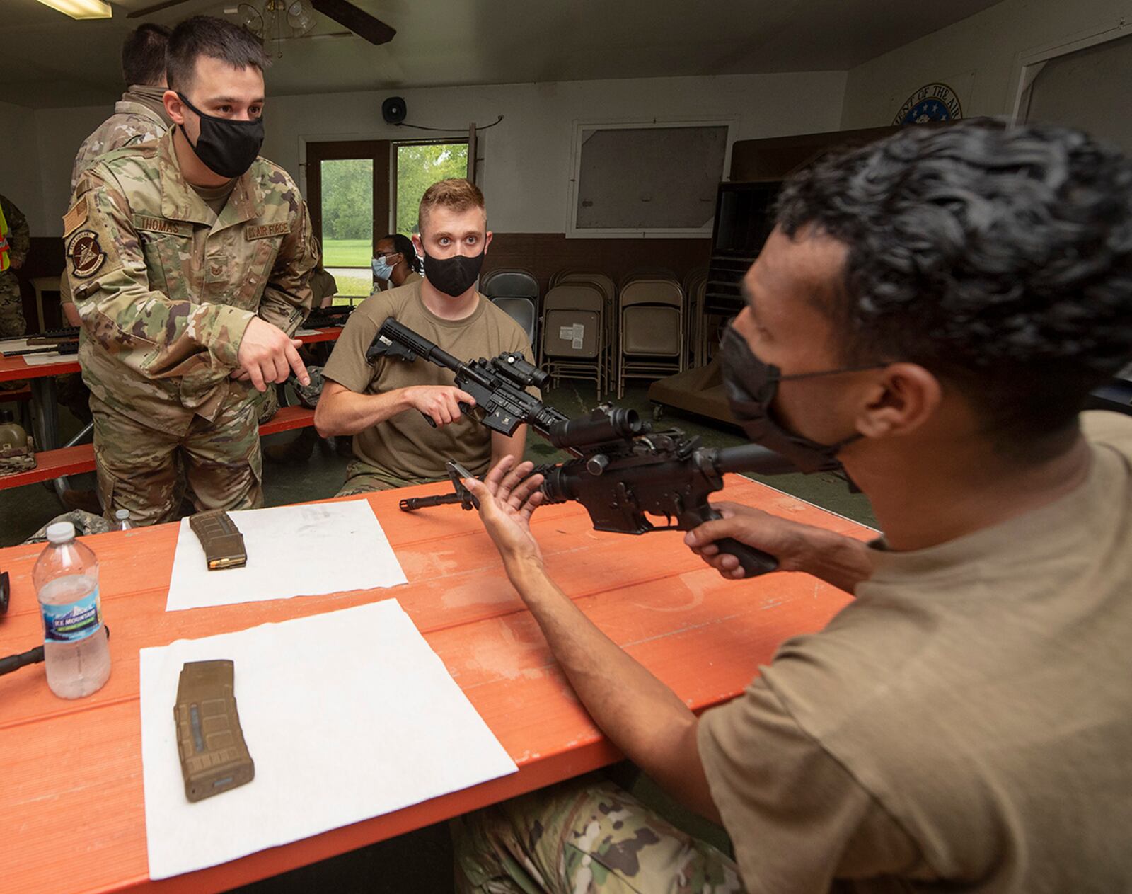 Tech. Sgt. Richard Thomas (left), NCO in charge of Combat Arms for the 88th Security Forces Squadron, works with Staff Sgt. Andrew Young (center) and Airman 1st Class Matthew Lennon, both with the 88th Communications Squadron, on the M4 rifle during training Aug. 11 at the Warfighter Training Center. U.S. AIR FORCE PHOTO/R.J. ORIEZ