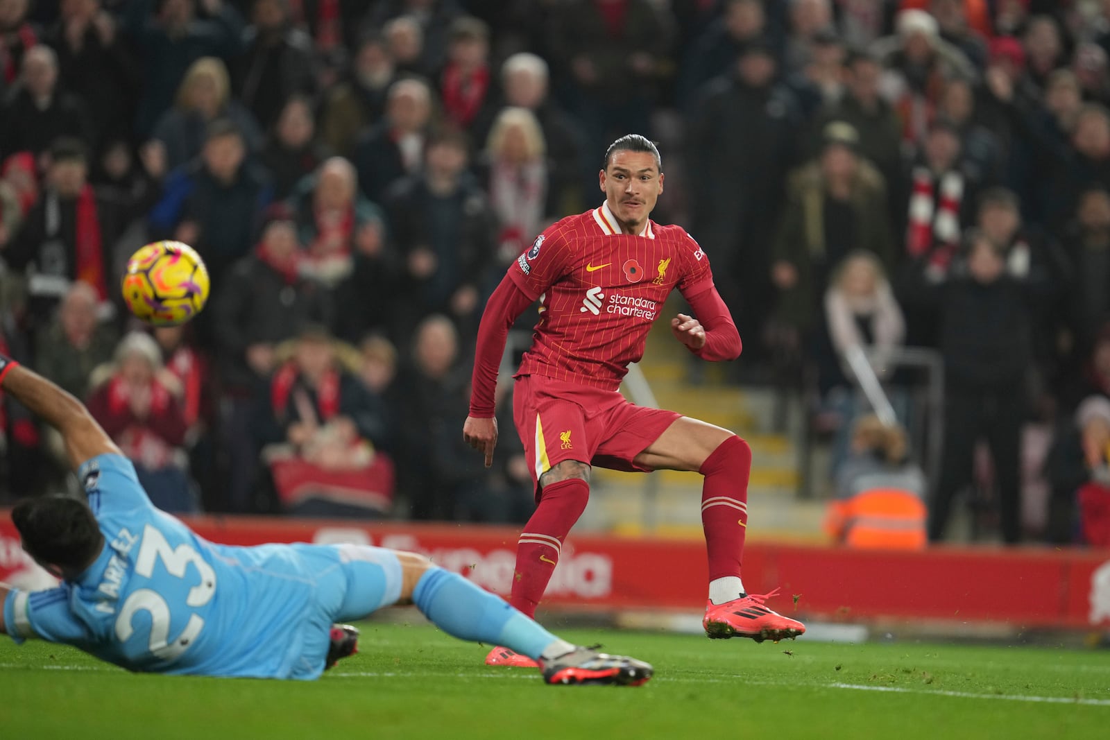 Liverpool's Darwin Nunez, right, scores his side's first goal against Aston Villa's goalkeeper Emiliano Martinez during the English Premier League soccer match at the Anfield stadium in Liverpool, Saturday, Nov. 9, 2024. (AP Photo/Jon Super)