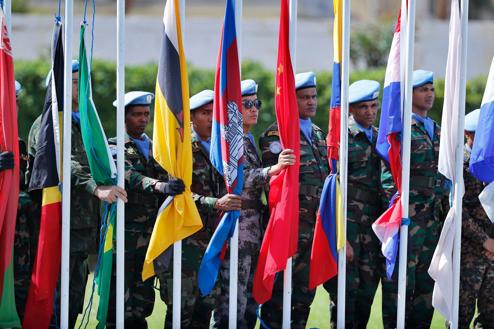 FILE - Peacekeepers representing 41 different national contingents that make up the United Nations Interim Force in Lebanon (UNIFIL), prepare to raise flags during a ceremony to mark the 40th anniversary of its peacekeeping presence in southern Lebanon, at the mission headquarters in the coastal town of Naqoura, Lebanon, Monday, March 19, 2018. (AP Photo/Hassan Ammar, File)