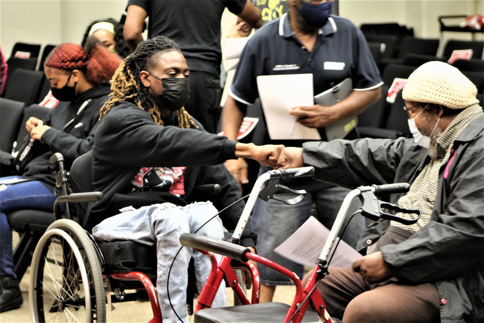 Clifford Owensby bumps fists with Bishop Richard Cox before Wednesday's Dayton City Commission meeting. Cox and others called on the city to suspend and fire the officers who pulled Owensby from his vehicle during a traffic stop last month. CORNELIUS FROLIK / STAFF