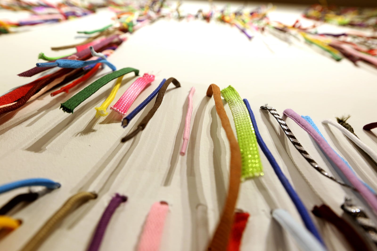 Volunteers hang thousands of shoelaces at The Contemporary Dayton Wednesday to create We The People, a 50-foot-wide wall installation designed by artist Nari Ward. The installation pairs humble of materials (shoelaces) with one of the country’s most lofty and enduring ideas—the U.S. Constitution, according to a release. The artwork will be on display through Nov. 30. The Co has also partnered with the League of Women Voters of the Greater Dayton Area to transform a portion of the gallery into a voter registration center.  LISA POWELL / STAFF