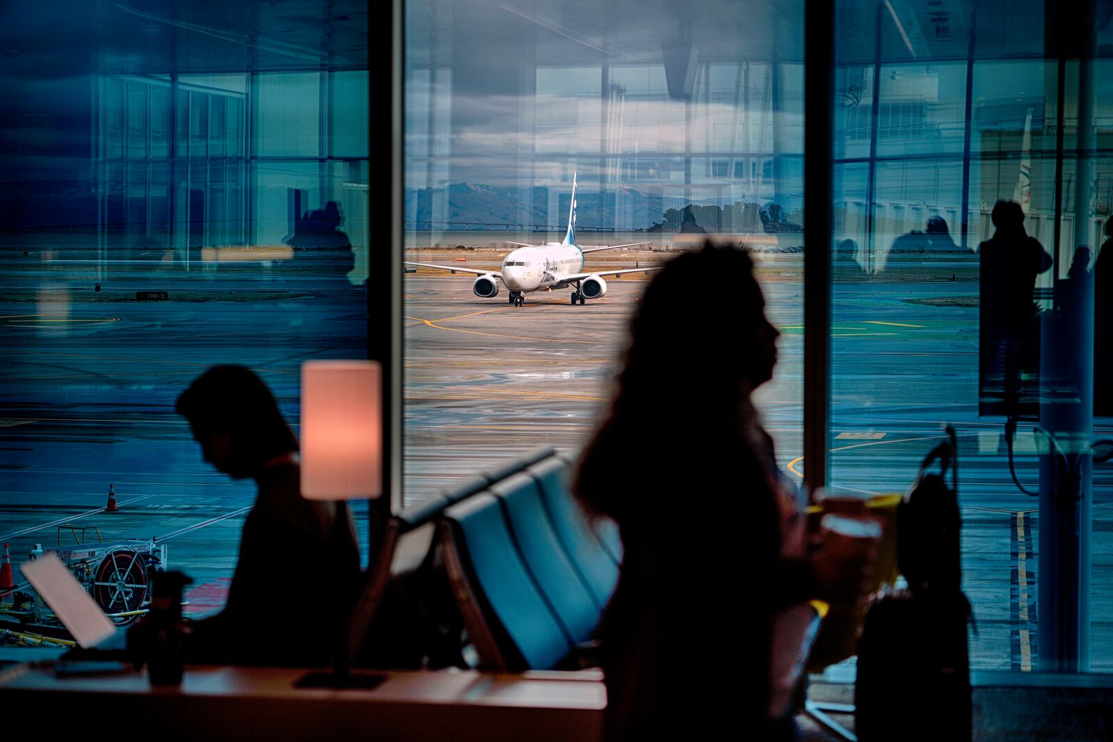 A passenger plane taxes on a water soaked runway at San Francisco Airport while passengers wait for flights on Thursday, Nov. 21, 2024, in San Francisco. (AP Photo/Andy Bao)