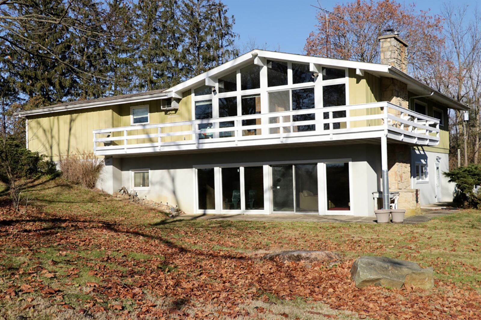 A wall of windows fills both the great room and kitchen area with natural light. Triple patio doors open to the wrap-around wooden deck with views of the front yard, side yard and wooded area along the creek. Natural light fills the lower-level room through windows and patio doors, which open to a concrete patio. CONTRIBUTED PHOTO BY KATHY TYLER