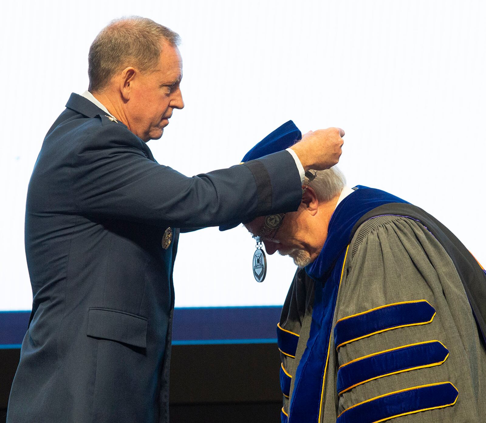 Lt. Gen. James Hecker, Air University commander and president, places the Air Force Institute of Technology chain-of-office around Dr. Walter Jones as he accepts the role of director and chancellor during a ceremony July 27 at Wright-Patterson Air Force Base. U.S. AIR FORCE PHOTO/WESLEY FARNSWORTH