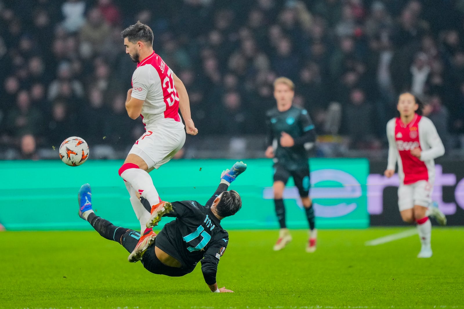 Ajax's Josip Sutalo duels for the ball with Lazio's Taty Castellanos, bottom, during the Europa League soccer match between Ajax and Lazio Roma at the Johan Cruyff Arena in Amsterdam, Netherlands, Thursday, Dec. 12, 2024. (AP Photo/Peter Dejong)