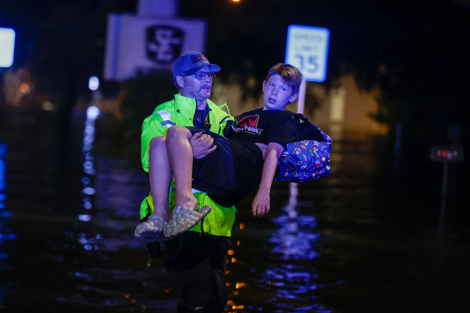 A Citrus County Firefigher carries 11-year- old, Michael Cribbins, while conducting rescues from floodwaters in the aftermath of Hurricane Helene on Friday, Sept. 27, 2024 in Crystal River, Fla. (Luis Santana/Tampa Bay Times via AP)