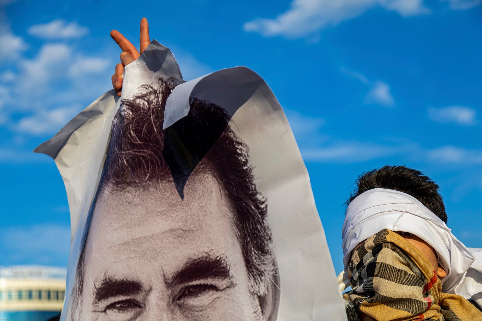 A youngster holds a photograph of the jailed leader of the rebel Kurdistan Workers' Party, or PKK, Abdullah Ocalan as they gather to watch live on a tv screen a Pro-Kurdish Peoples' Equality and Democracy Party, or DEM, delegation members releasing an statement from Ocalan, in Diyarbakir, Turkey, Thursday, Feb. 27, 2025. (AP Photo/Metin Yoksu)