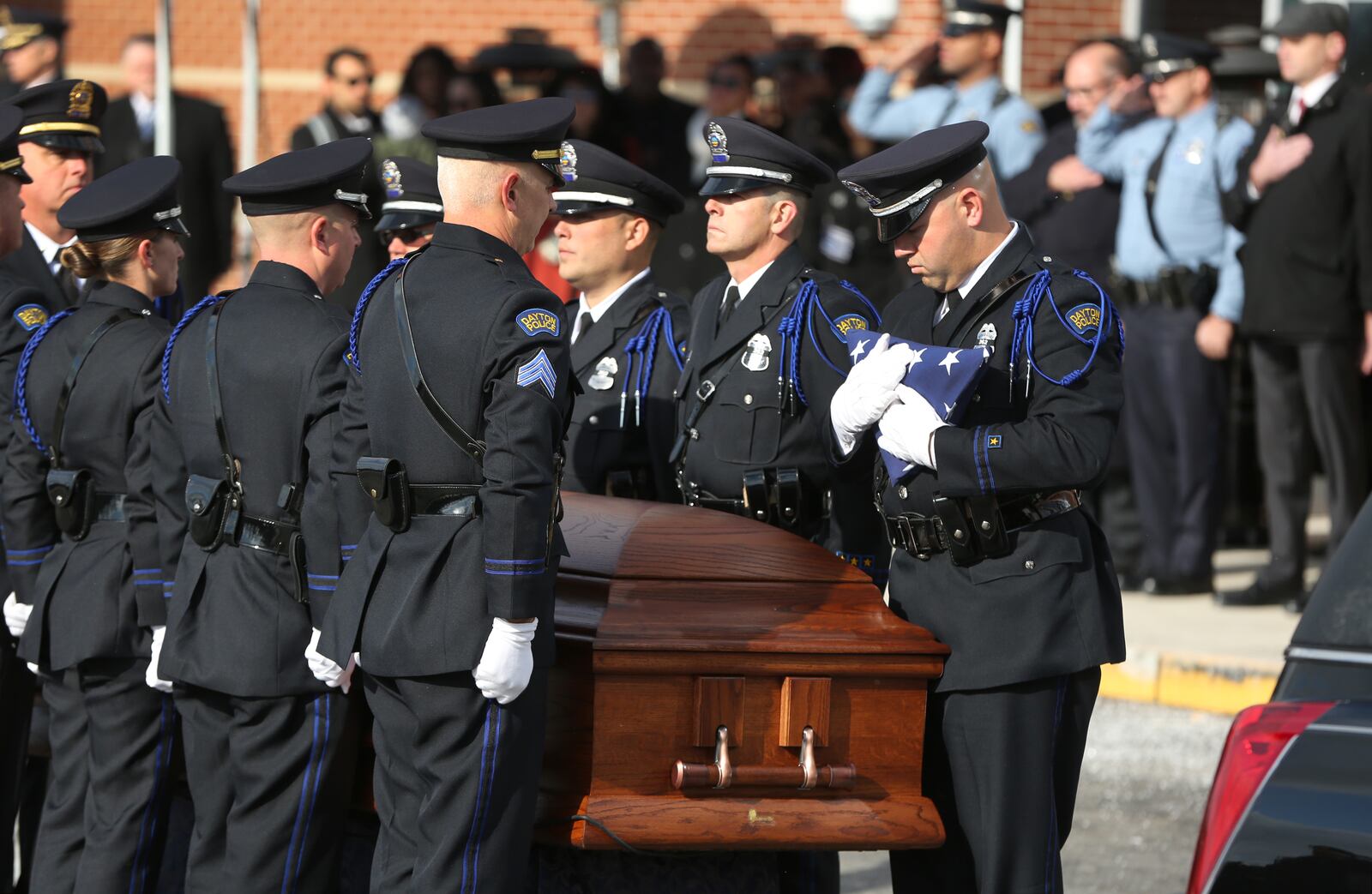 The flag that draped the casket of Dayton Police Detective Jorge Del Rio is folded during the honor service ceremony held after the funeral Tuesday at Univerisity of Dayton Arena. LISA POWELL / STAFF