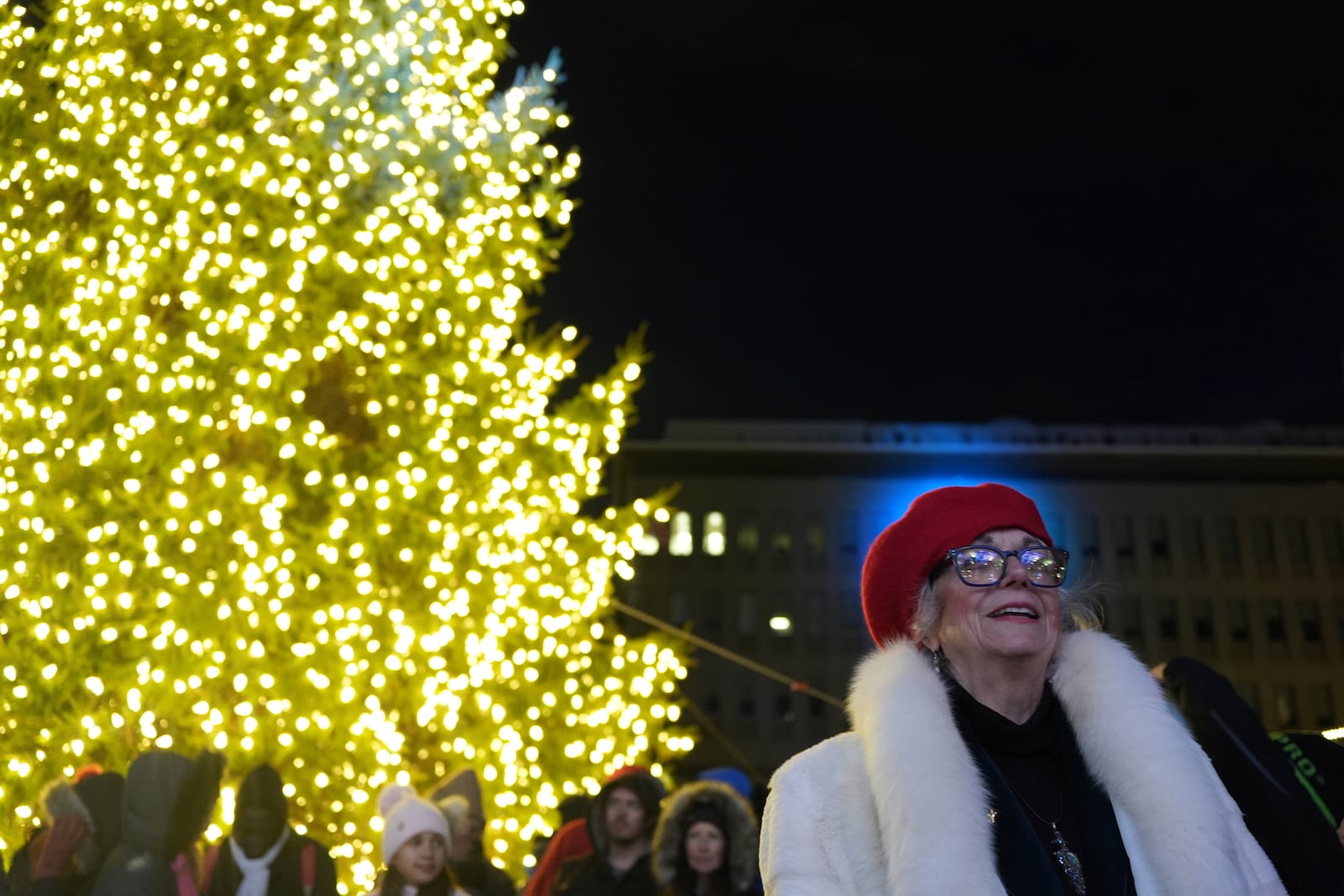 A woman smiles during the lighting of a Christmas tree on Payrow Plaza in Bethlehem, Pa., known as “Christmas City, USA,” on Sunday, Friday, Nov. 29, 2024. (AP Photo/Luis Andres Henao)