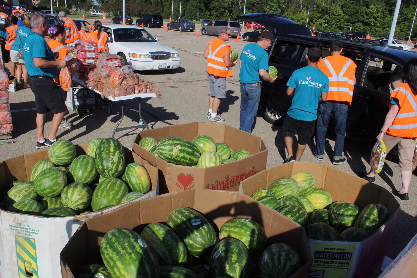 Volunteers gathered at the Nutter Center for a food giveaway in August. The event was a partnership of CareSource and The Foodbank. CHUCK HAMLIN / STAFF