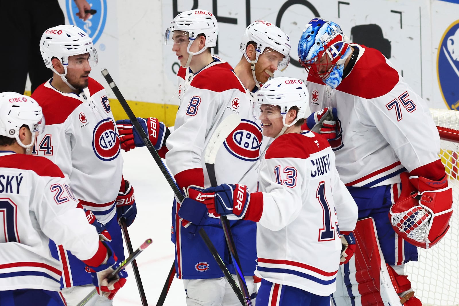 Montreal Canadiens players celebrate victory following the third period of an NHL hockey game against the Buffalo Sabres, Saturday, March 1, 2025, in Buffalo, N.Y. (AP Photo/Jeffrey T. Barnes)