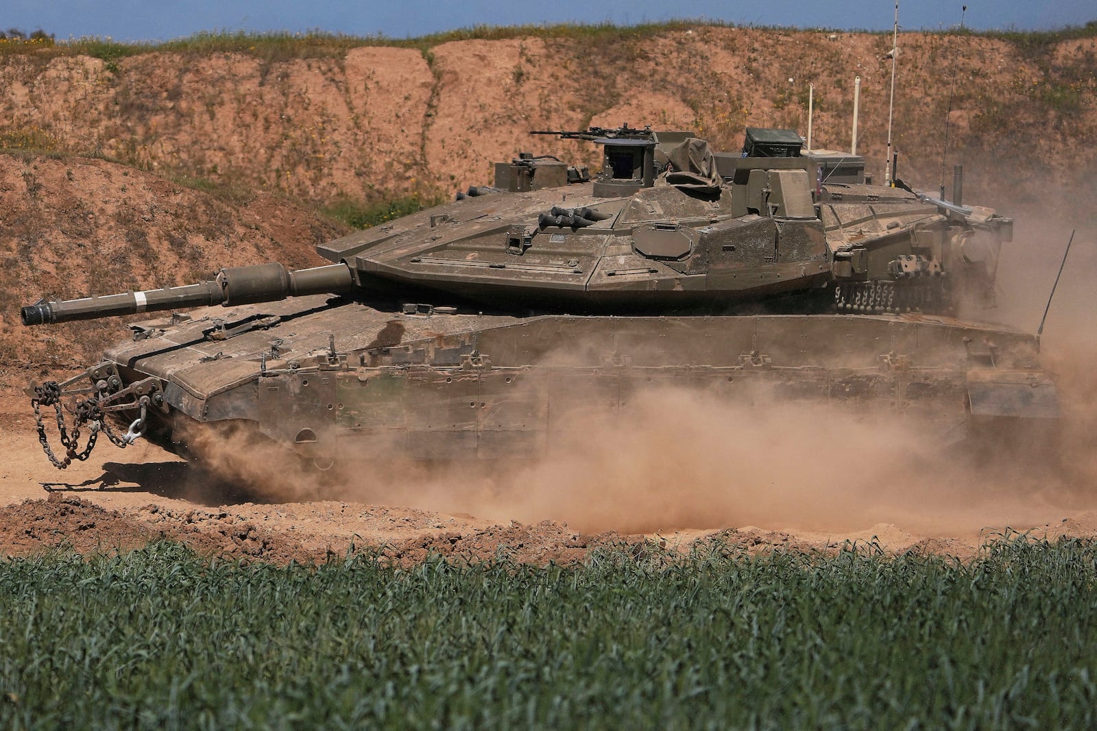 An Israeli tank maneuvers on the Gaza Strip border in southern Israel, Wednesday, March 19, 2025. (AP Photo/Ariel Schalit)