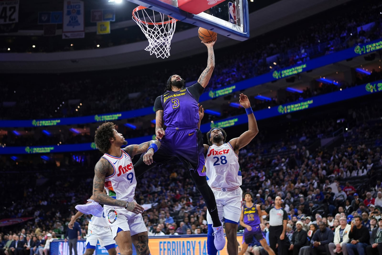 Los Angeles Lakers' Anthony Davis (3) goes up for a shot against Philadelphia 76ers' Guerschon Yabusele (28) and Kelly Oubre Jr. (9) during the first half of an NBA basketball game, Tuesday, Jan. 28, 2025, in Philadelphia. (AP Photo/Matt Slocum)