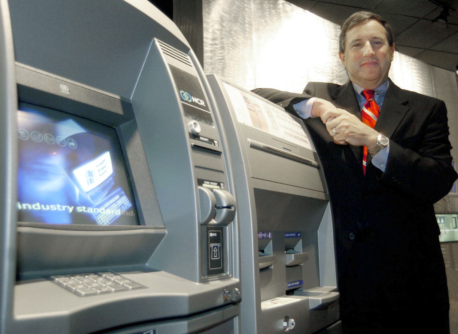 Mark Hurd, then President and CEO of NCR Corp., stands with one the company’s ATMs inside the Business Solutions Center Friday, June 11, 2004 in Dayton.